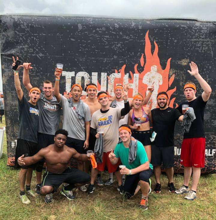 Group of us posing in front of the tough mudder finisher sign