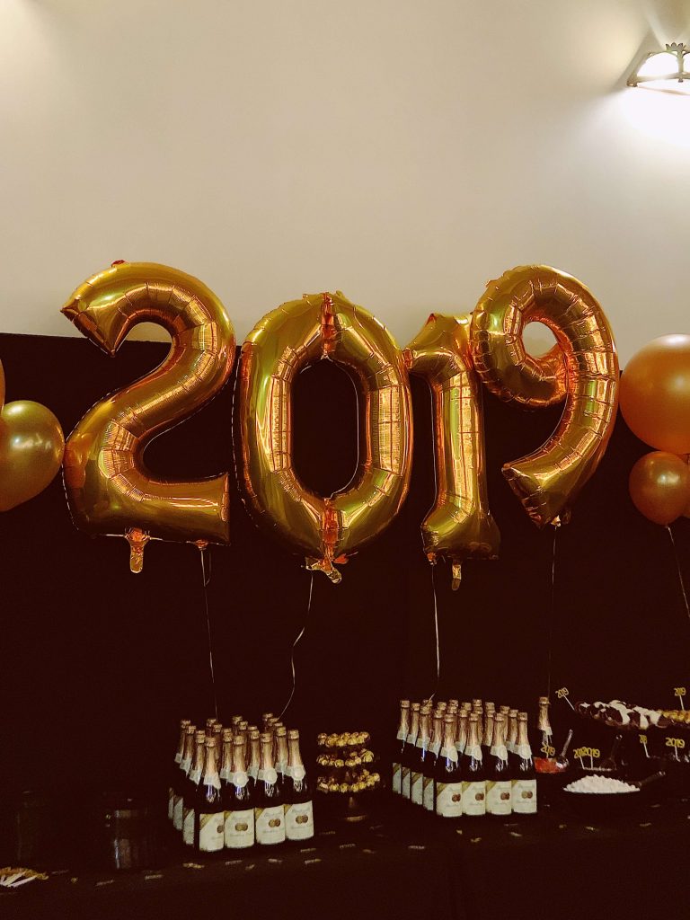 Balloons in the shape of 2019 in front of table with champagne bottles