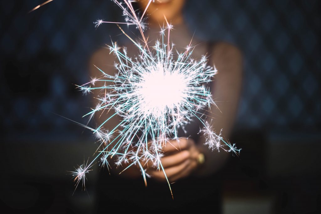 woman holding sparkler in front of her with two hands