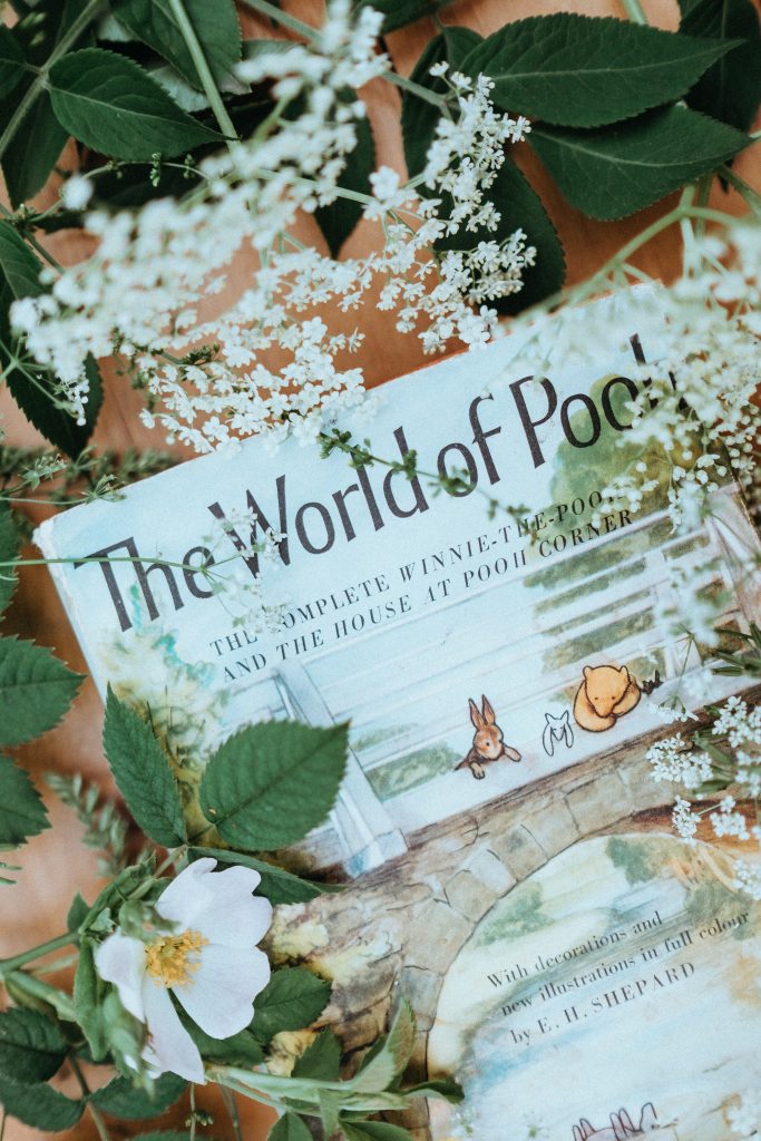 The World of Pooh Book surrounded by flowers